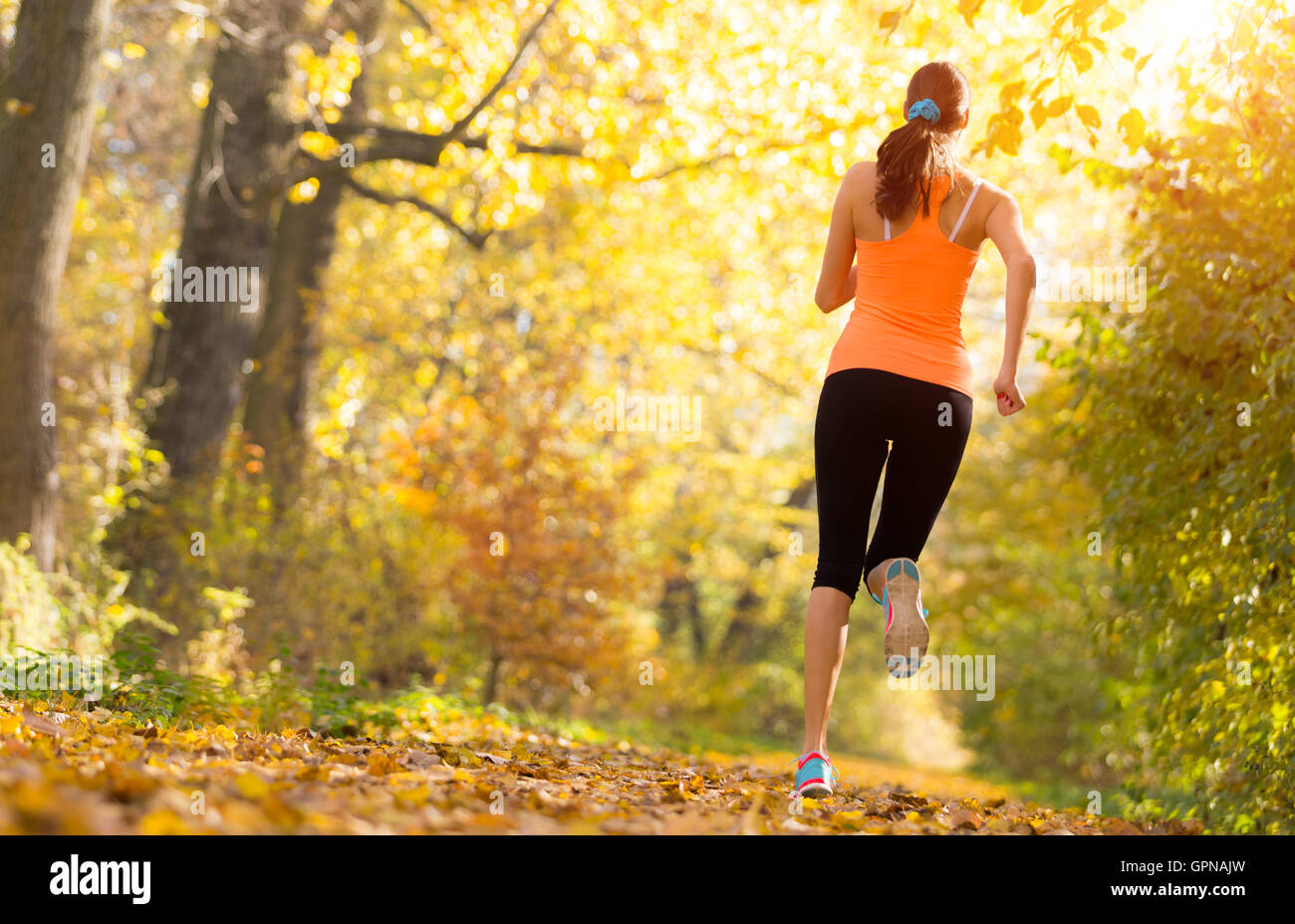 Athlete young woman running in morning sunrise training for marathon and fitness. Healthy active lifestyle in outdoor. Photograp Stock Photo