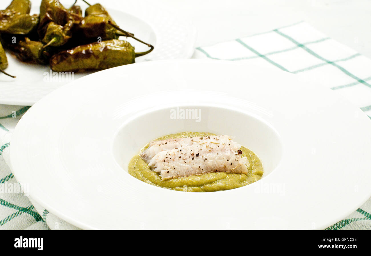 Fish cooked baked cod with friggitelli cooked in a pan with oil and garlic , typical Italian vegetables,italy Stock Photo