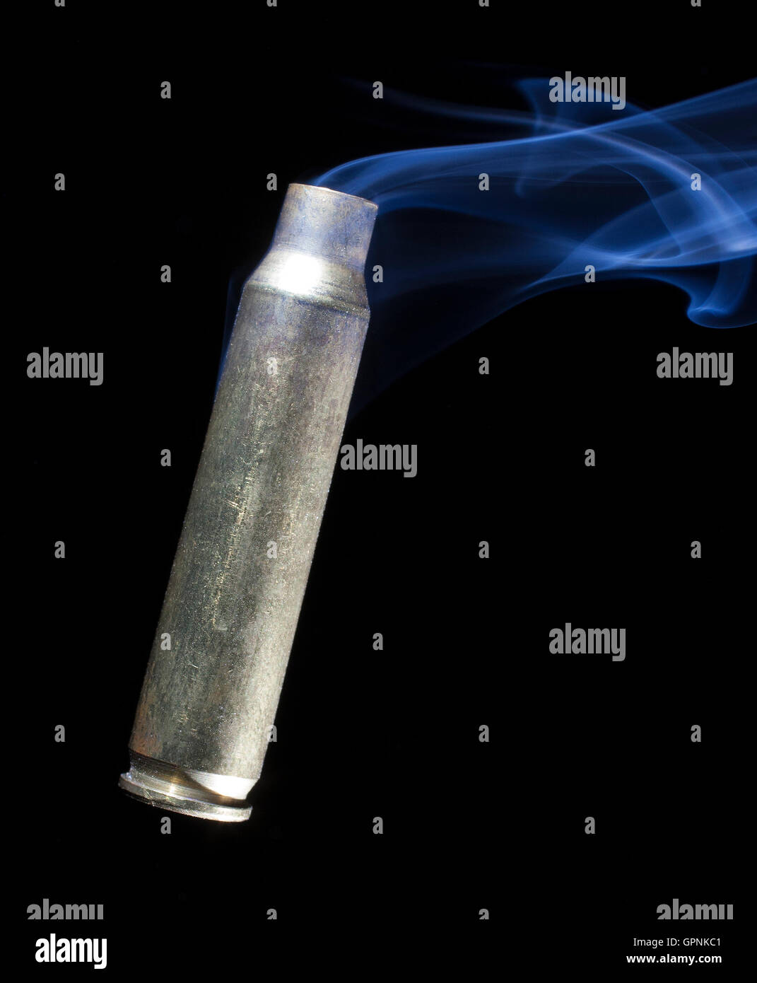 Brass casing from a rifle cartridge that is empty with smoke coming out