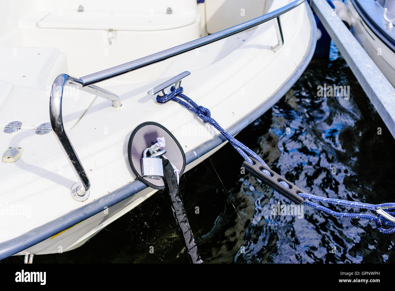 Padlock and covered chain secure the boat from random theft. Stock Photo