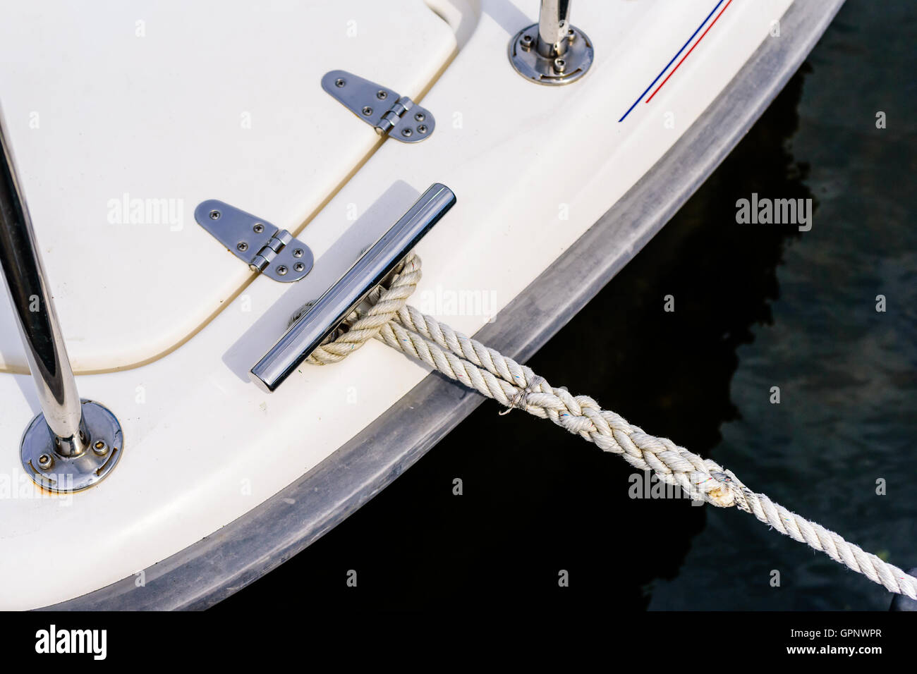 Tight rope attached to boat moored at marina. Stock Photo