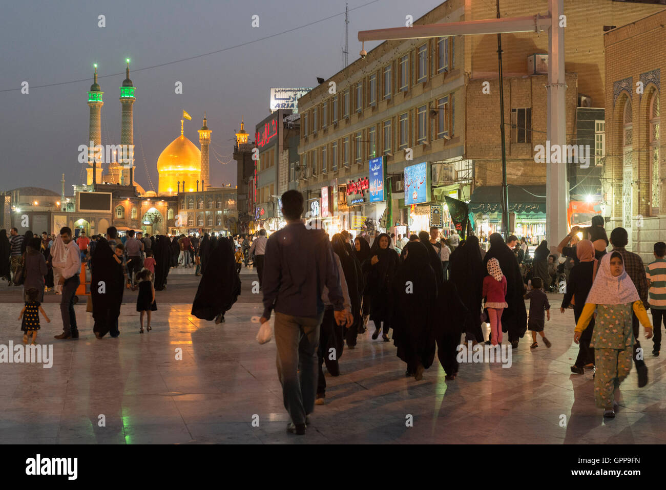 Qom, Pilgrims In Street Outside Fatima Masumeh Shrine (Fātimah al-Ma‘sūmah, Sister Of ‘Alī al-Riđā) At Dusk Stock Photo