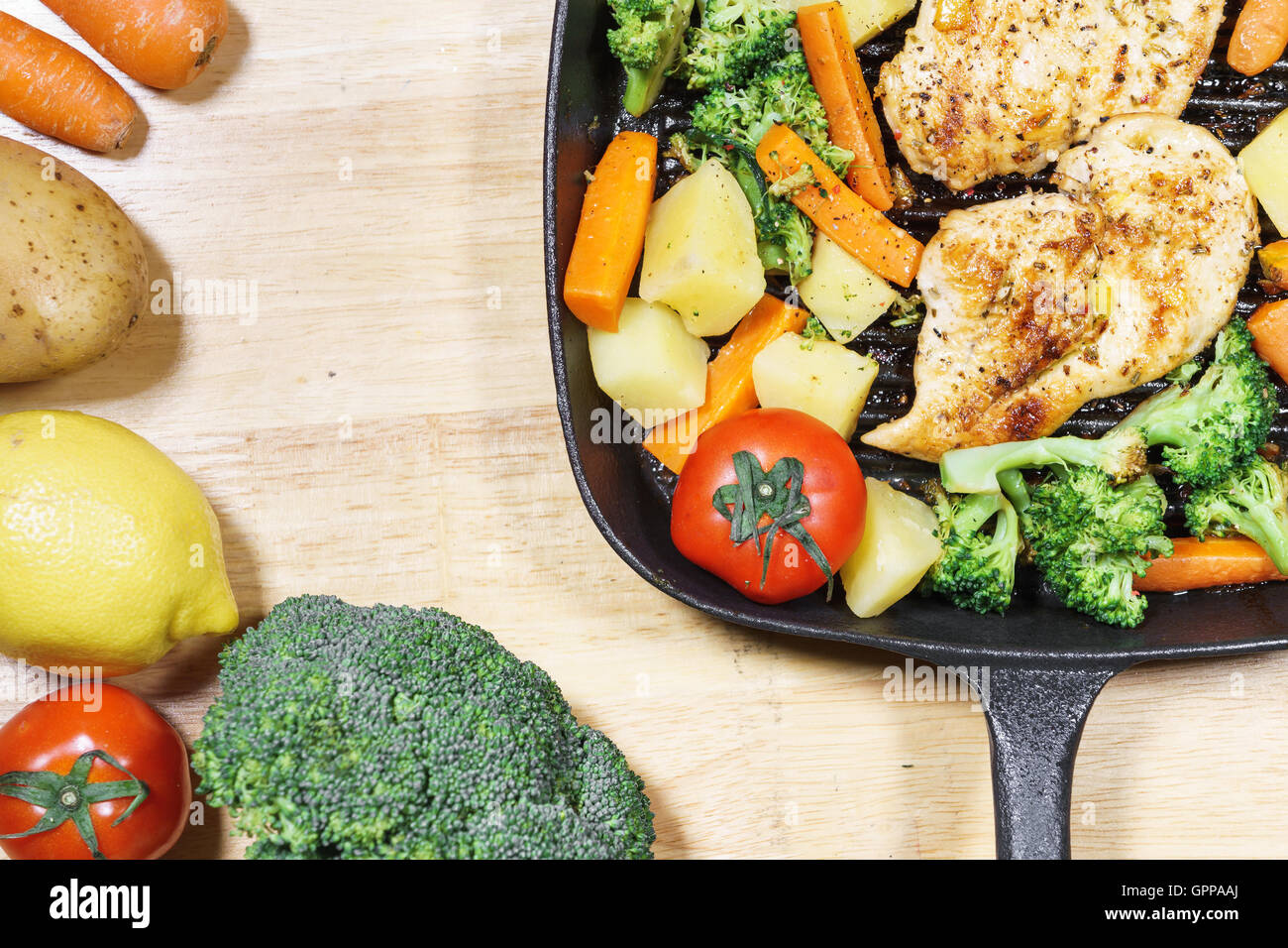 Lemon grilled chicken breast with fried vegetables in pan Stock Photo