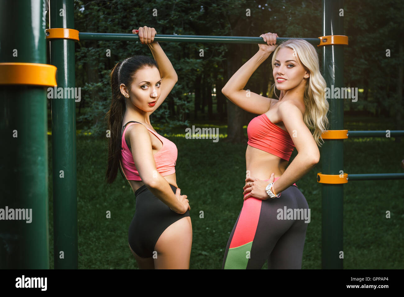 Concept: sport, healthy lifestyle. Young strong girls do exercises during street workout Stock Photo