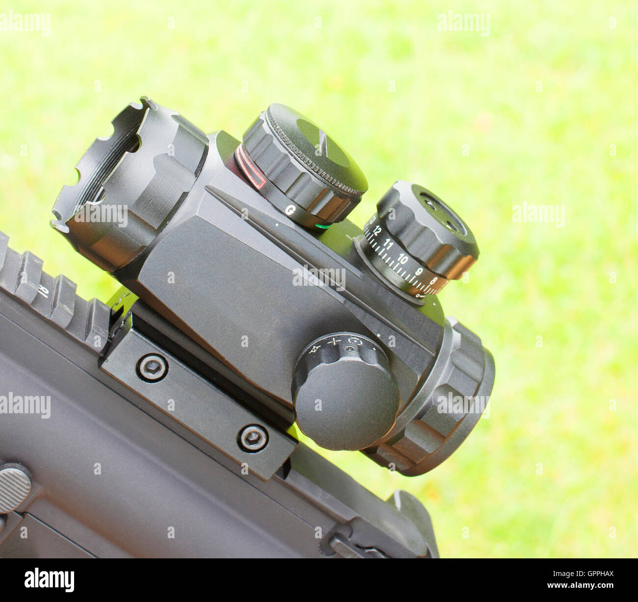 Short Rifle Scope Mounted On A Gun With A Green Background Stock Photo 