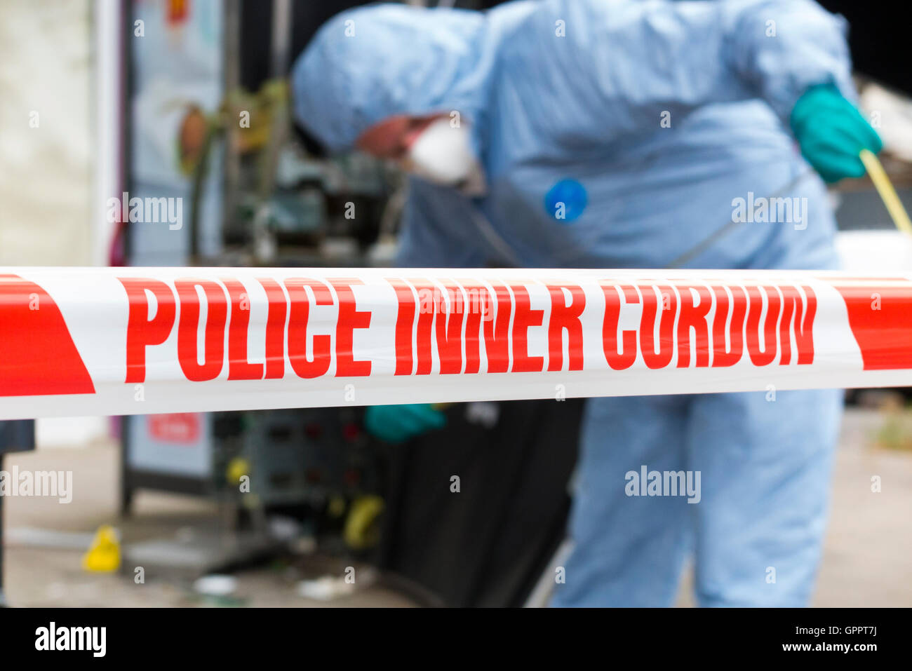Police inner cordon tape barrier and a scene of crime officer