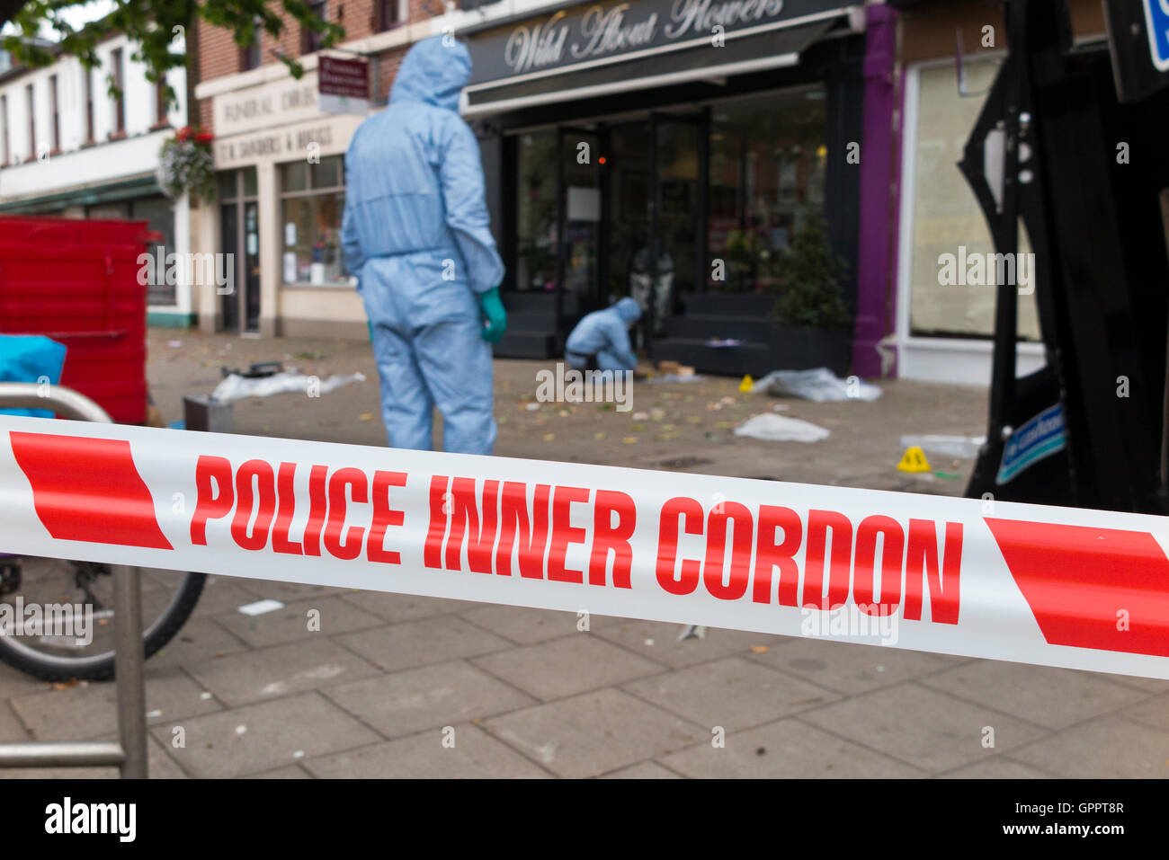 Police inner cordon tape barrier and a scene of crime officer