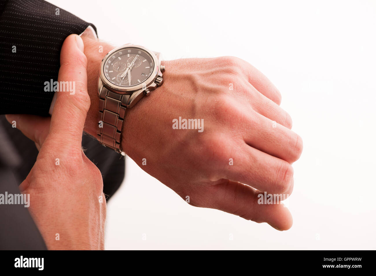 Successful businessman in formal suit checking time on wrist watch isolated over white. Stock Photo