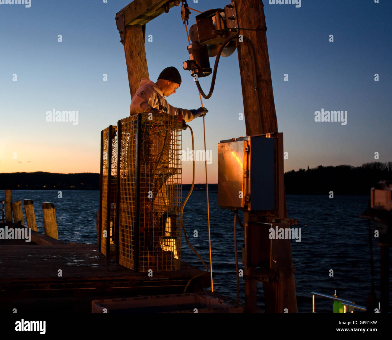 A fisherman unloads his boat at the Town Dock on a December evening in Bar Harbor, Maine. Stock Photo