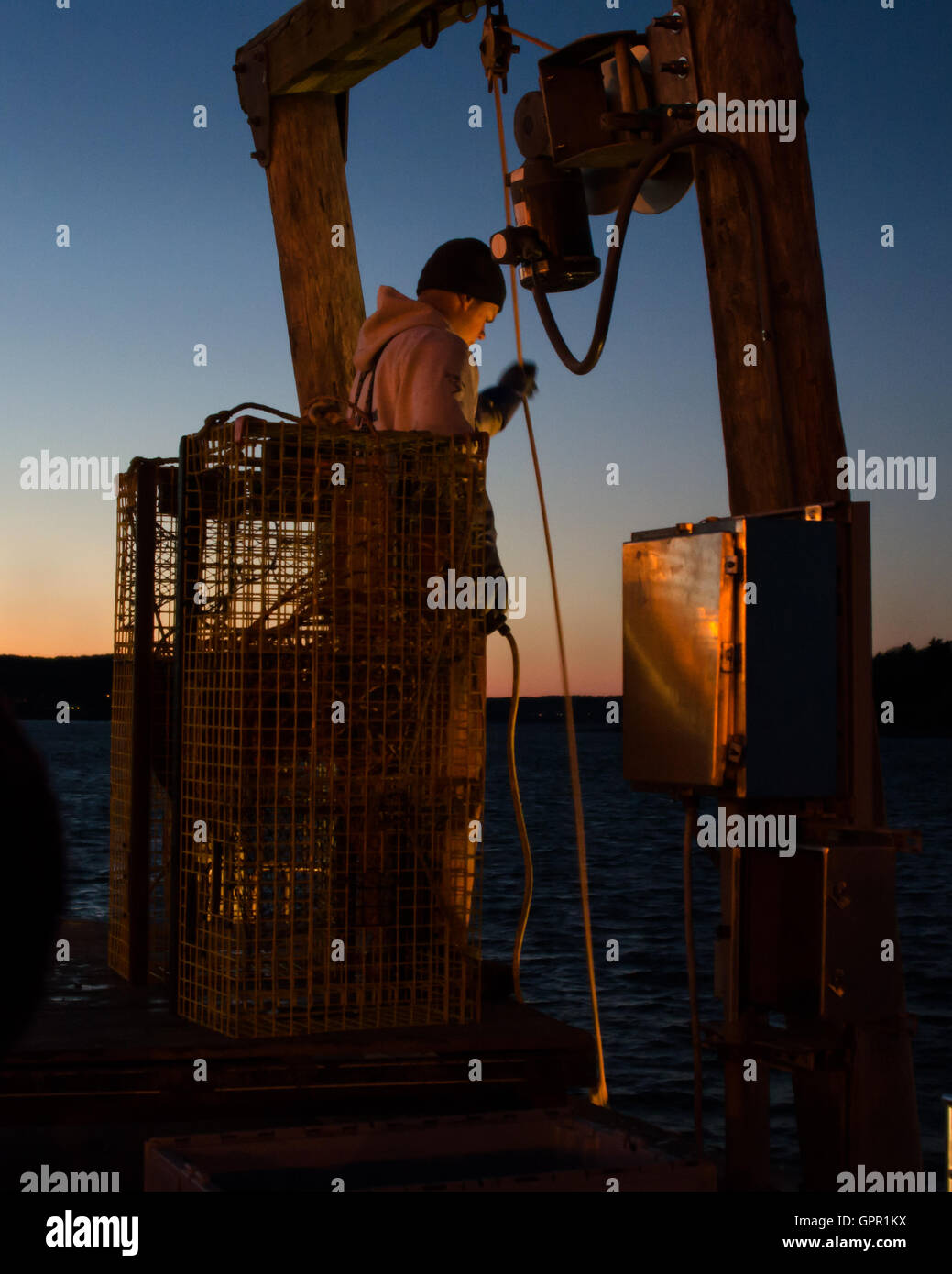 A fisherman unloads his boat at the Town Dock on a December evening in Bar Harbor, Maine. Stock Photo