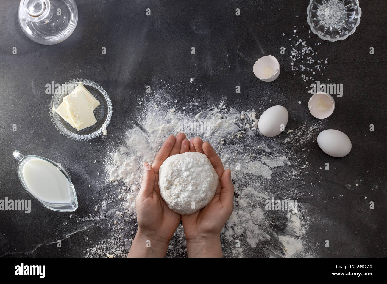 Woman's hands knead dough on table with flour Stock Photo - Alamy