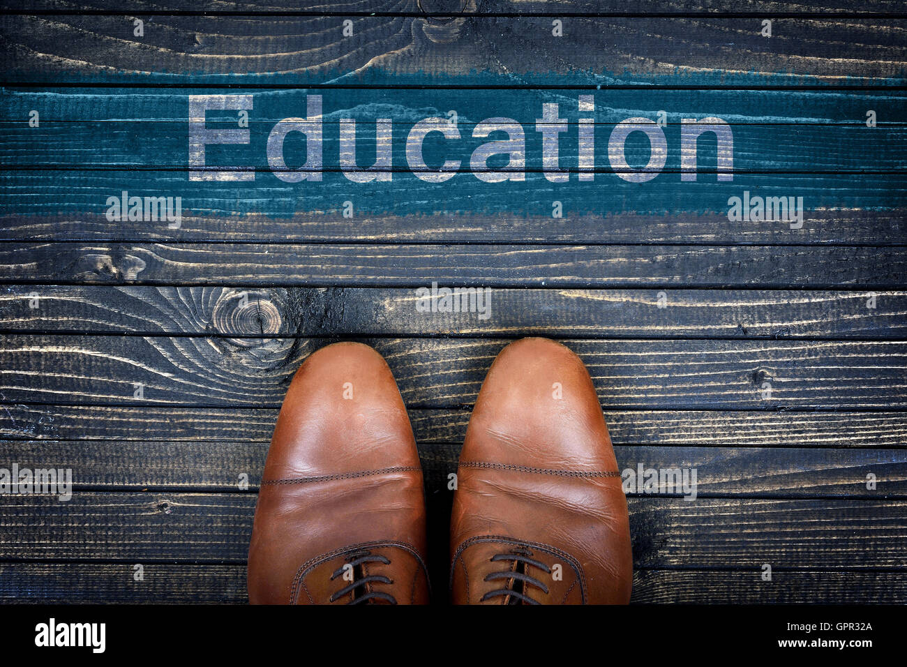 Education message and business shoes on wooden floor Stock Photo