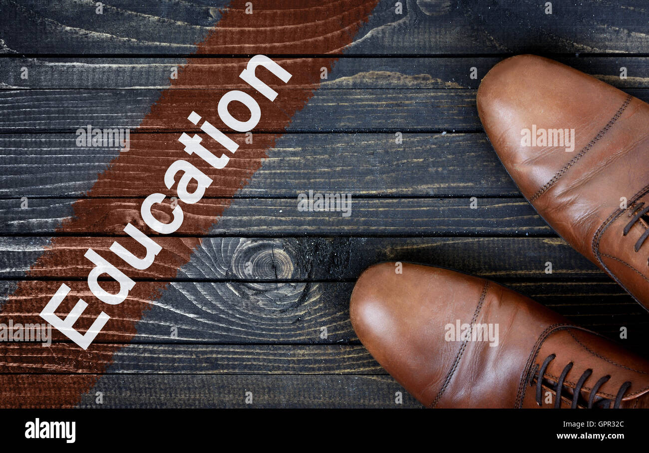Education message and business shoes on wooden floor Stock Photo