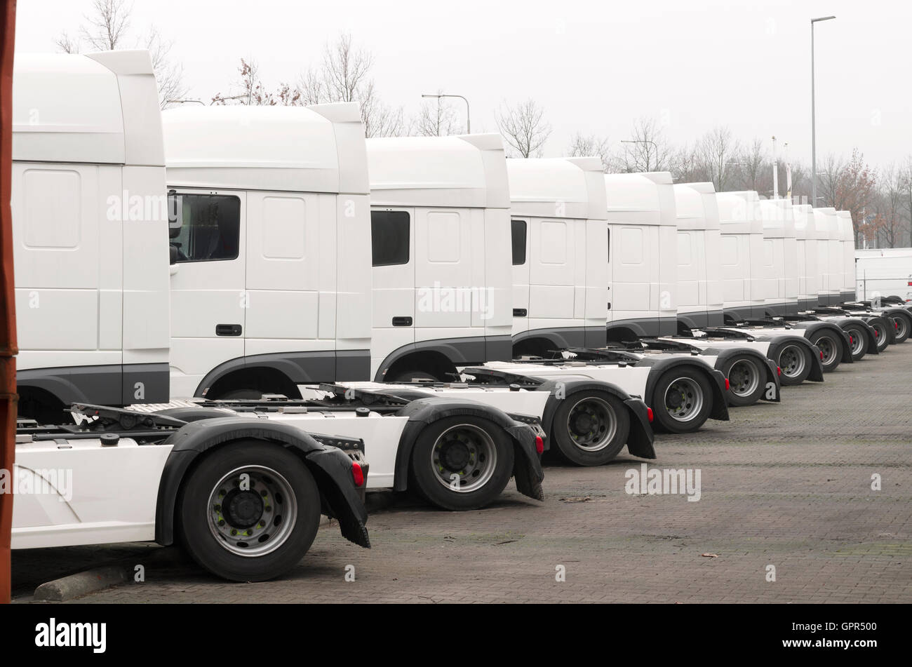 long line of white trucks for sale on a parking place Stock Photo