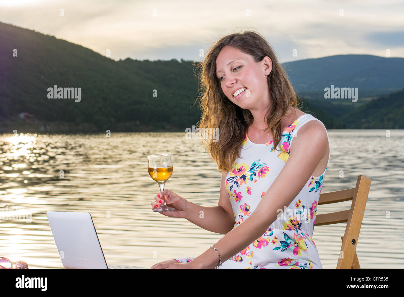 Young woman having a video call by the lake Stock Photo