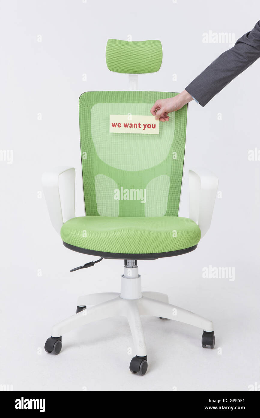Hand placing Helpwanted message on chair Stock Photo Alamy