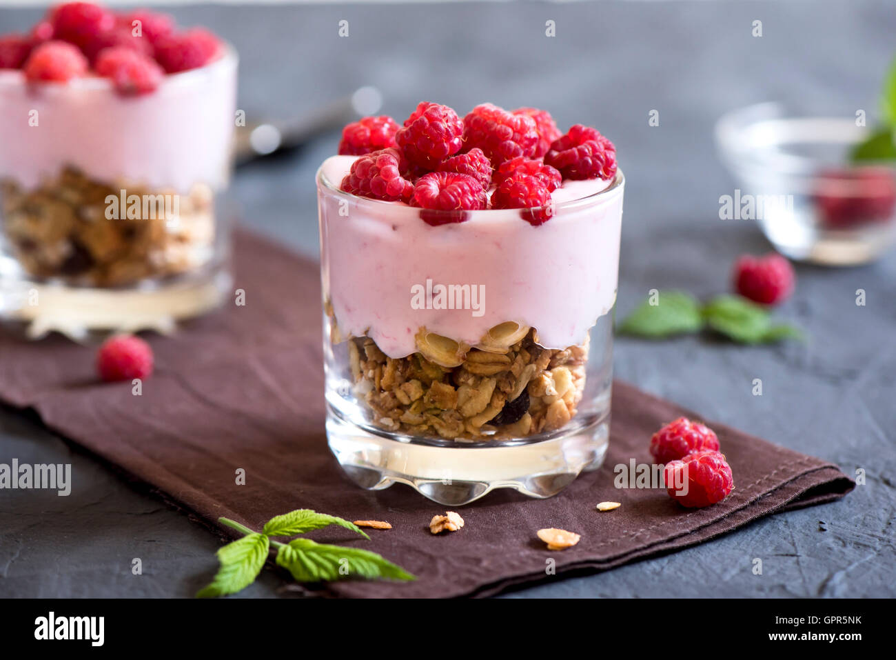 Homemade organic fresh parfait dessert with raspberries and granola, selective focus Stock Photo