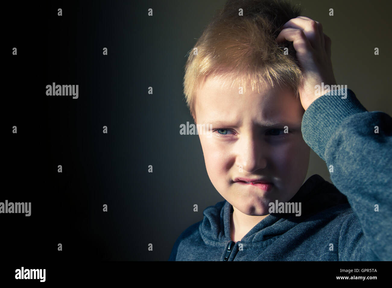 Boy (teen, kid) scratching head confused in trouble over dark