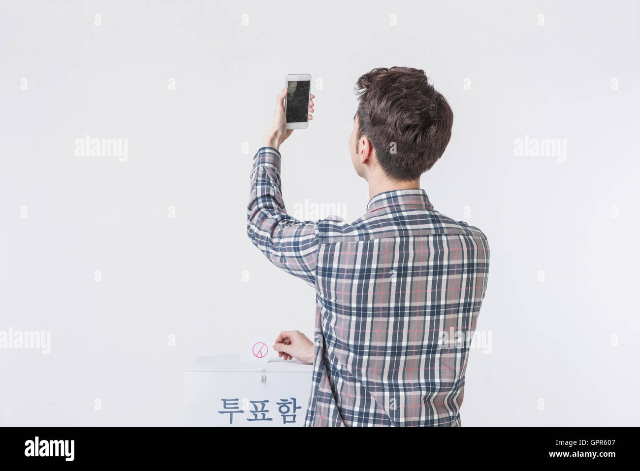 Back of male voter taking a selfie Stock Photo