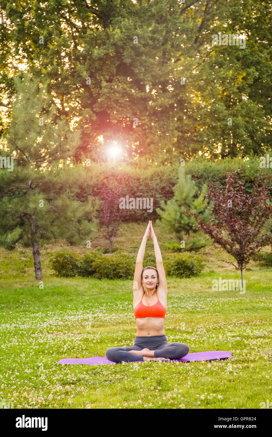 Young woman practicing yoga in the park Stock Photo - Alamy