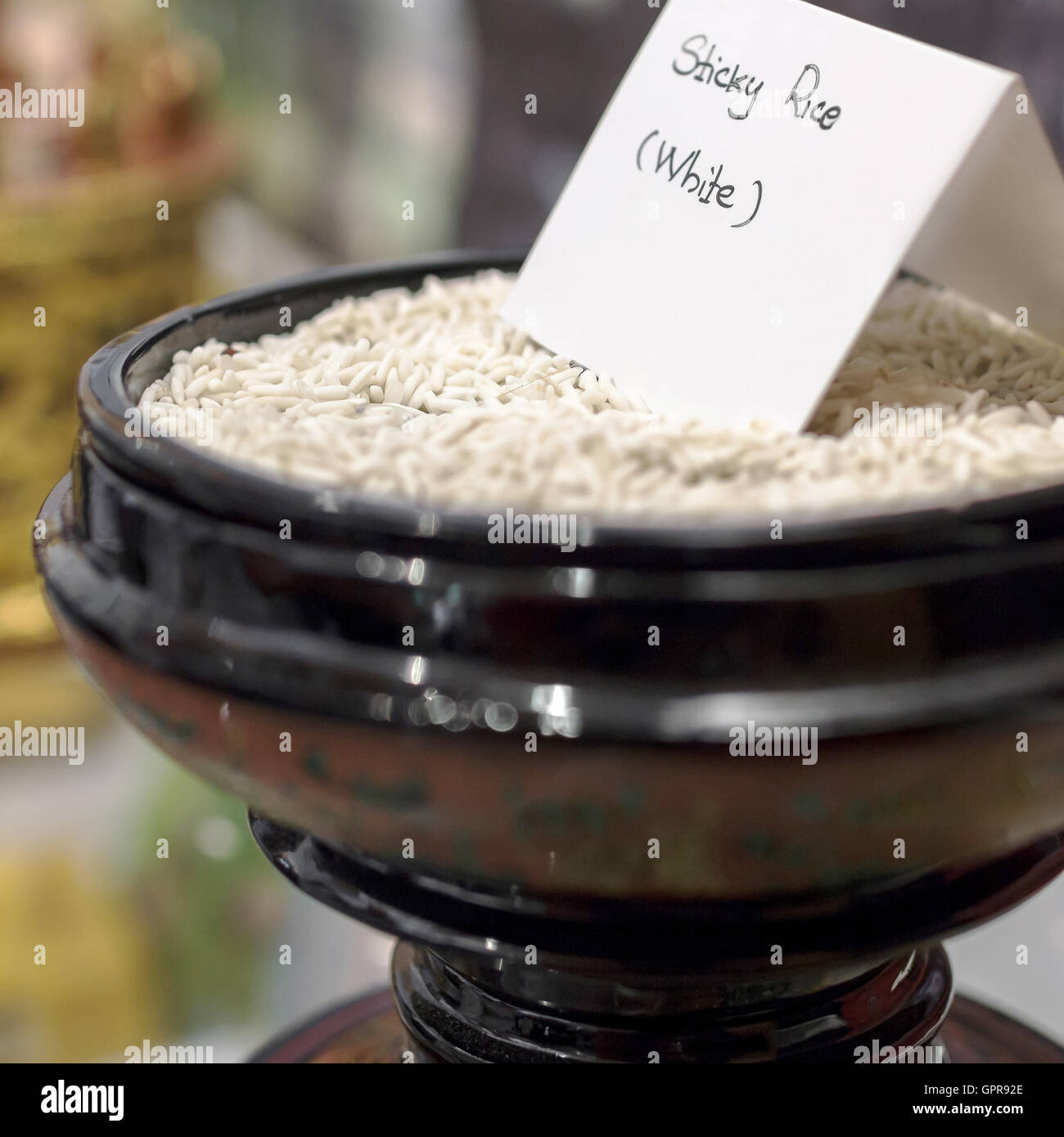 Uncooked sticky rice in oriental bowl. Extreme selective focus ...