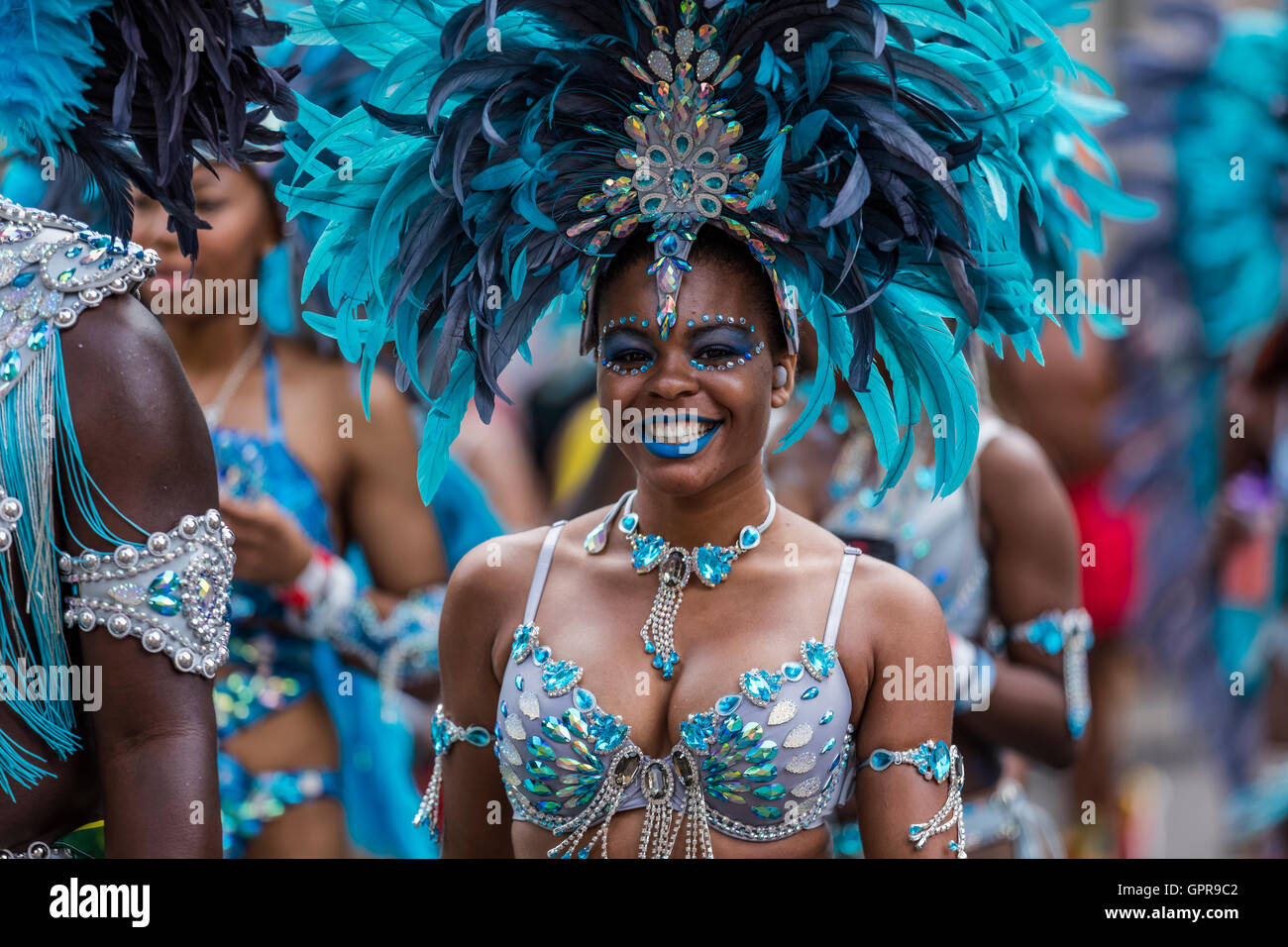 Beautiful West Indies girl dressed in blue with blue feather headdress at the Notting Hill carnival in West London Stock Photo