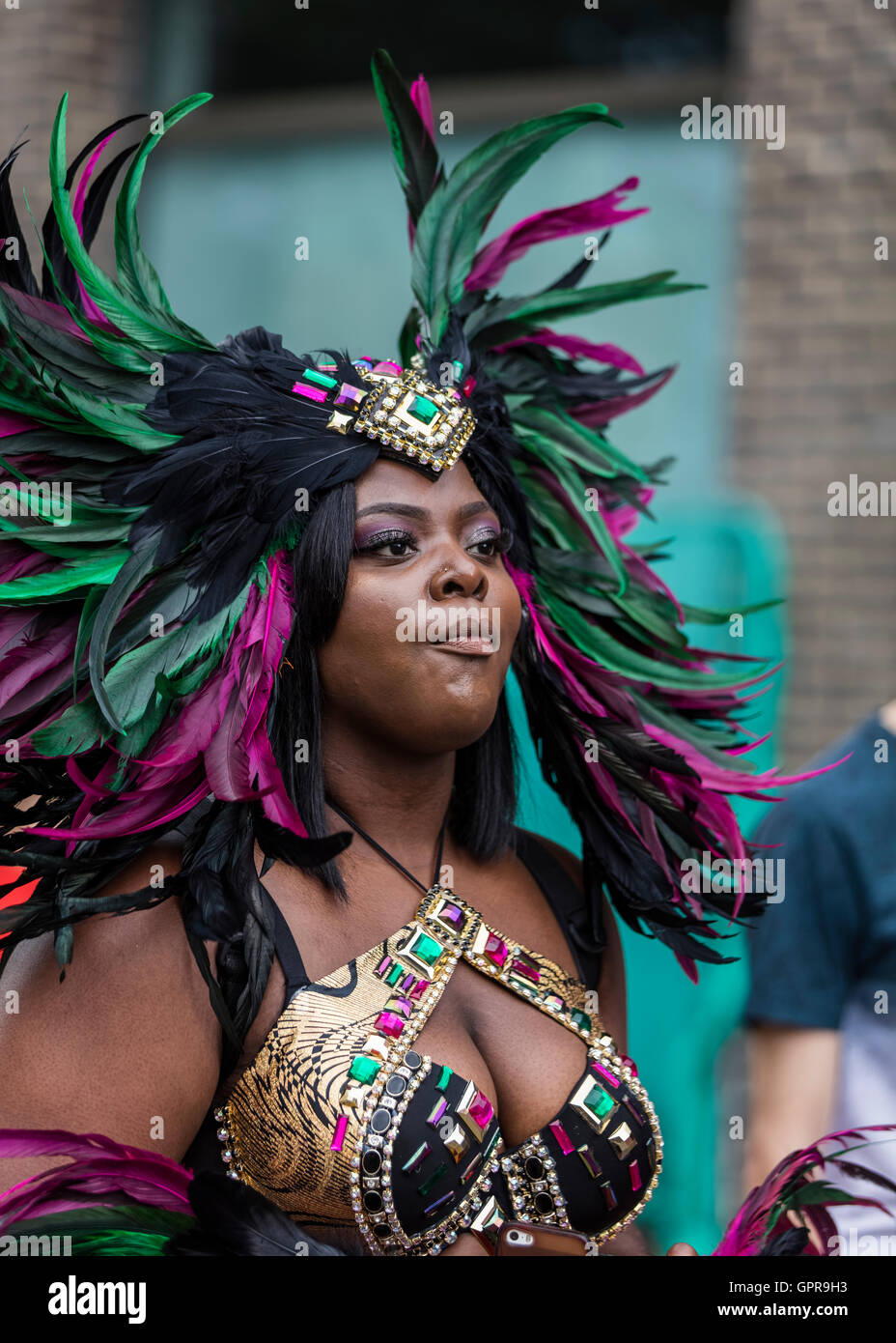 Beautiful black lady wearing colourful Notting Hill carnival feathers and costume Stock Photo
