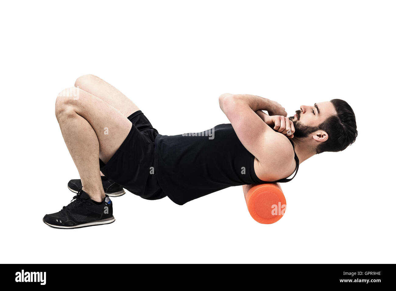 Athlete massaging upper back muscles with foam roller. Full body length