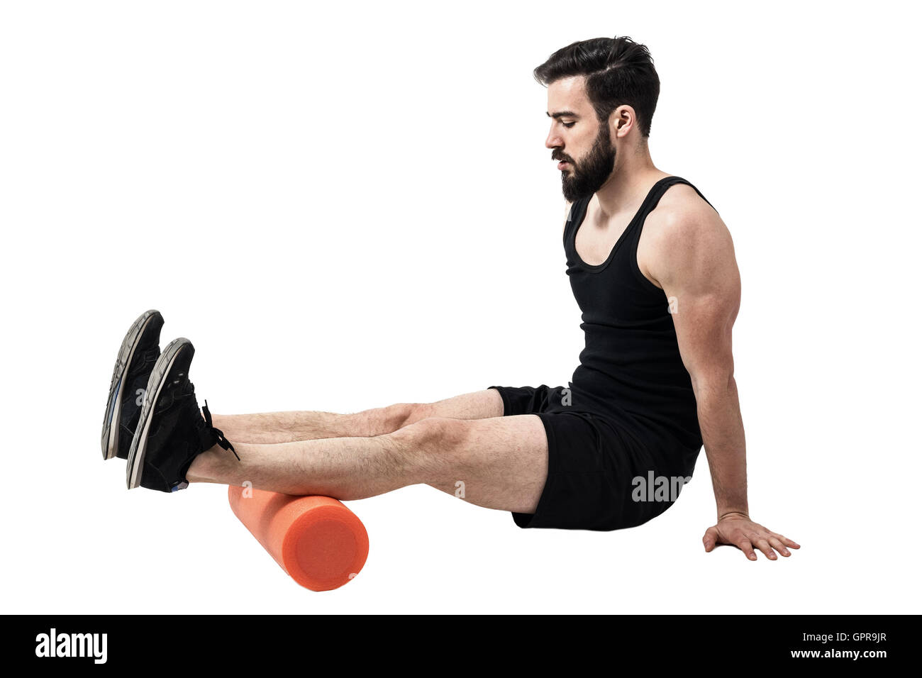 Athlete massaging and stretching hamstring leg muscles on foam roller