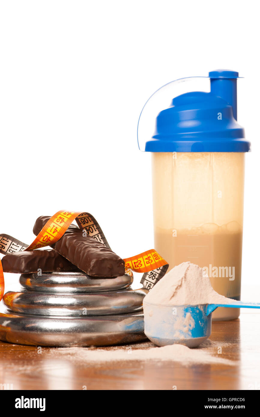 Whey protein powder in scoop, dumbbell, meter tape and plastic shaker
