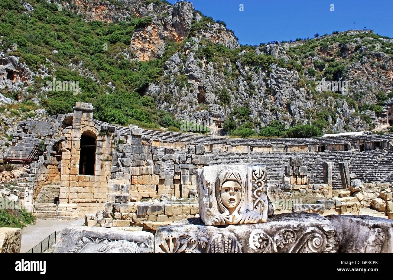 Mask, rock tombs and ancient theater in Myra, Turkey Stock Photo