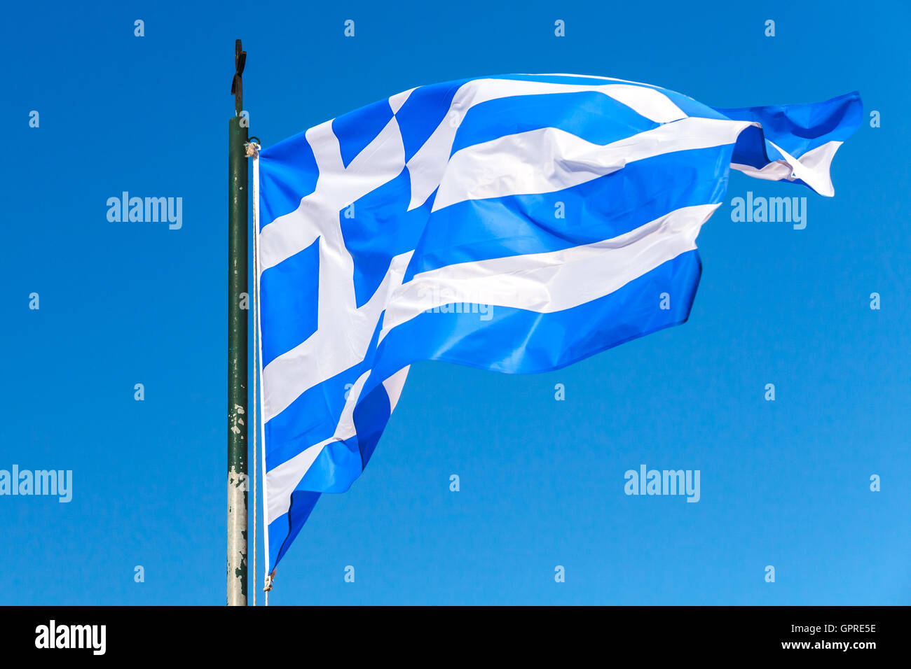 Flag of Greece waving on wind over clear blue sky background Stock Photo