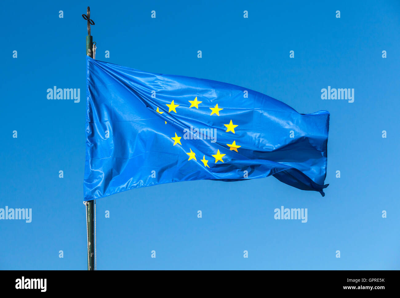 Flag of Europe, or European Flag waving on a flagpole over clear blue sky background Stock Photo