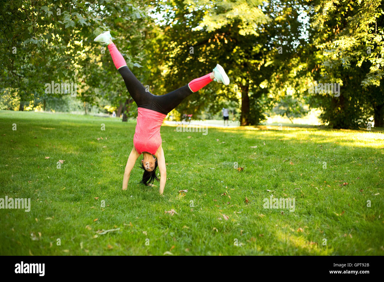 girl performing cartwheel in the park Stock Photo