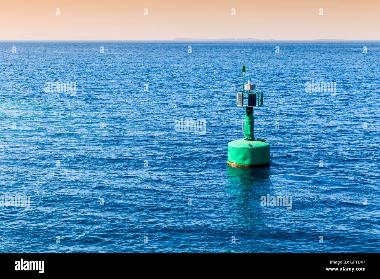 Green navigational buoy marker with solar panels in the sea Stock Photo