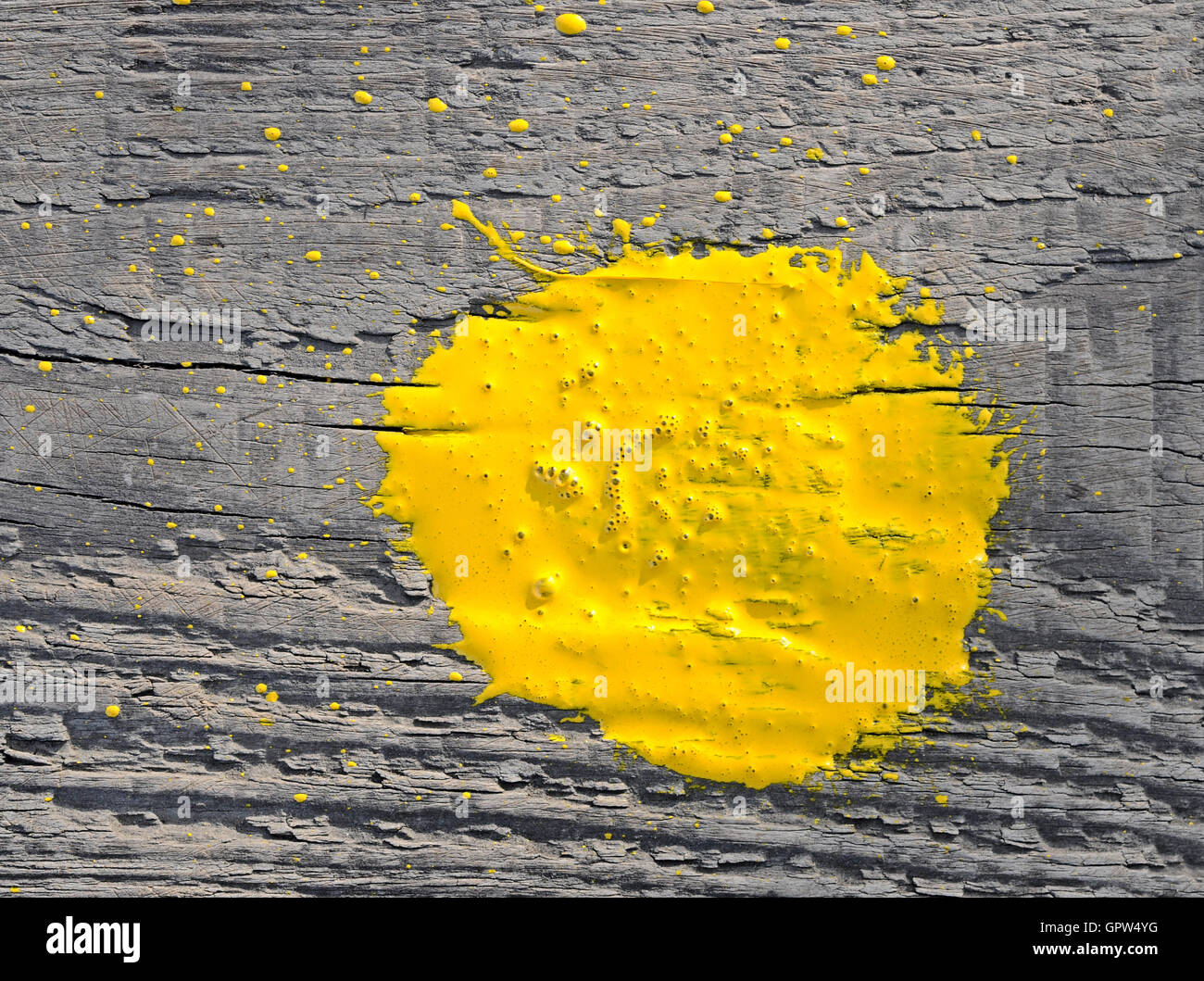 Yellow paint splashed over old wooden background Stock Photo