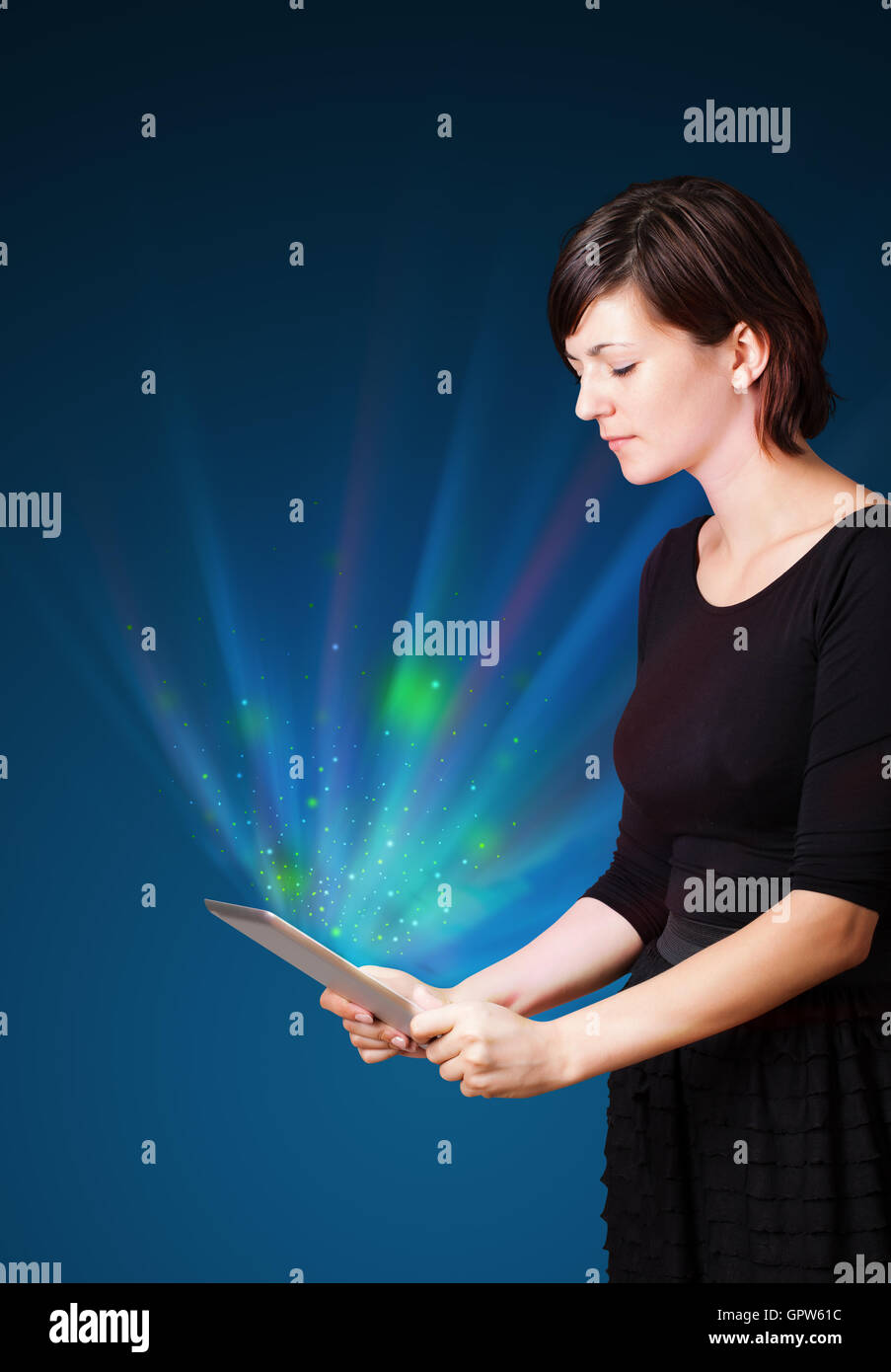 Young woman looking at modern tablet with abstract lights Stock Photo ...