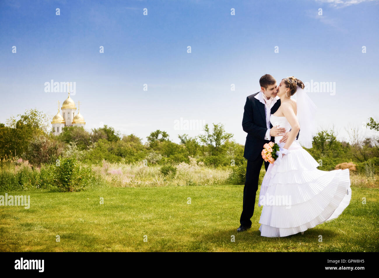kissing the bride in the park Stock Photo - Alamy