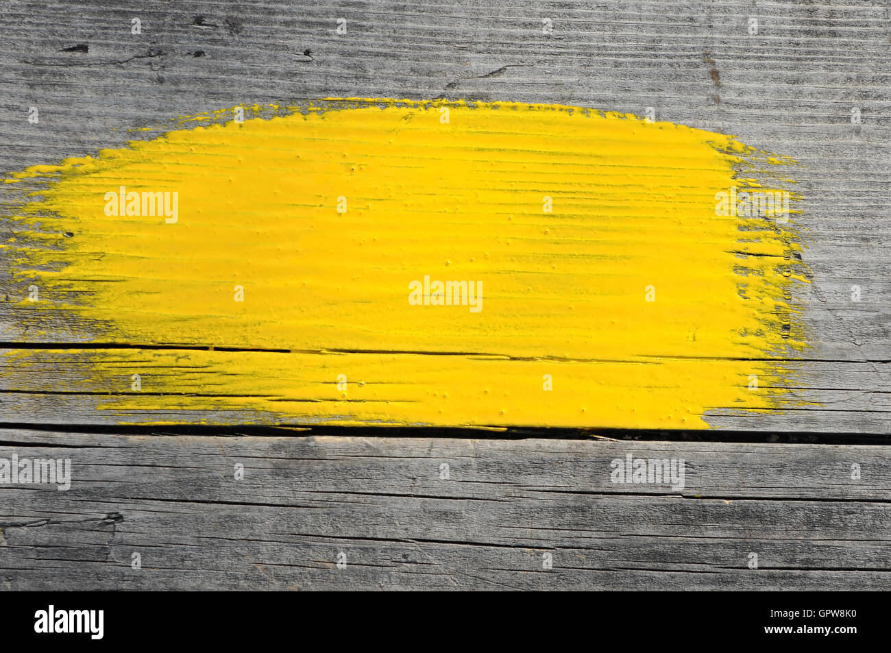 yellow stroke of the paint brush on wooden background Stock Photo