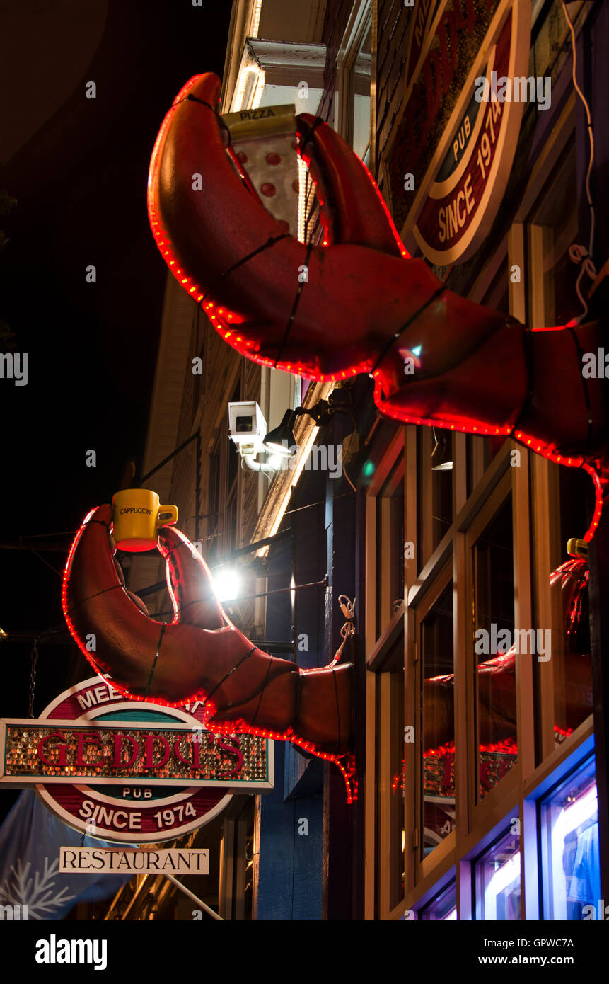 Christmas lights outline the lobster-claw signs for Geddy's Pub in Bar Harbor, Maine. Stock Photo