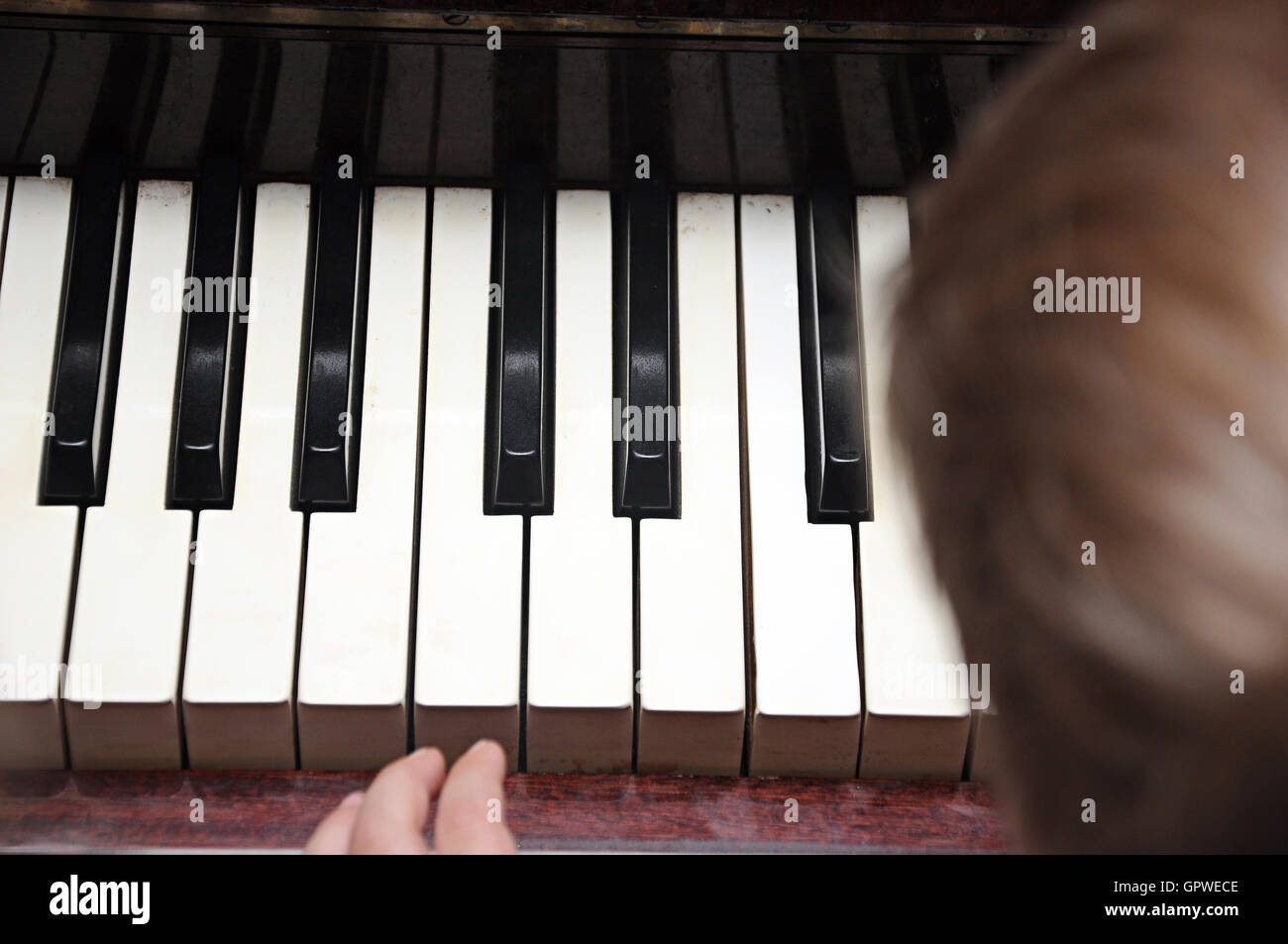 A cute baby plays with a piano. Stock Photo