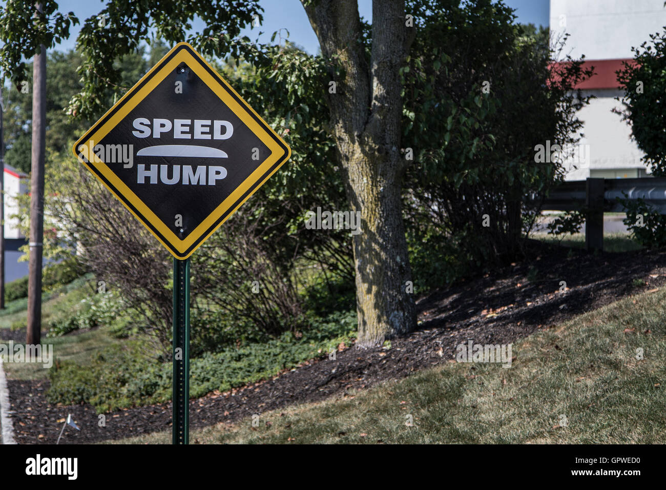 A 'Speed Hump ' sign by a road. Stock Photo