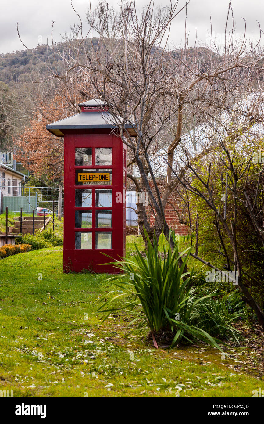 An old style red telephone booth in a grassy country lane Stock Photo