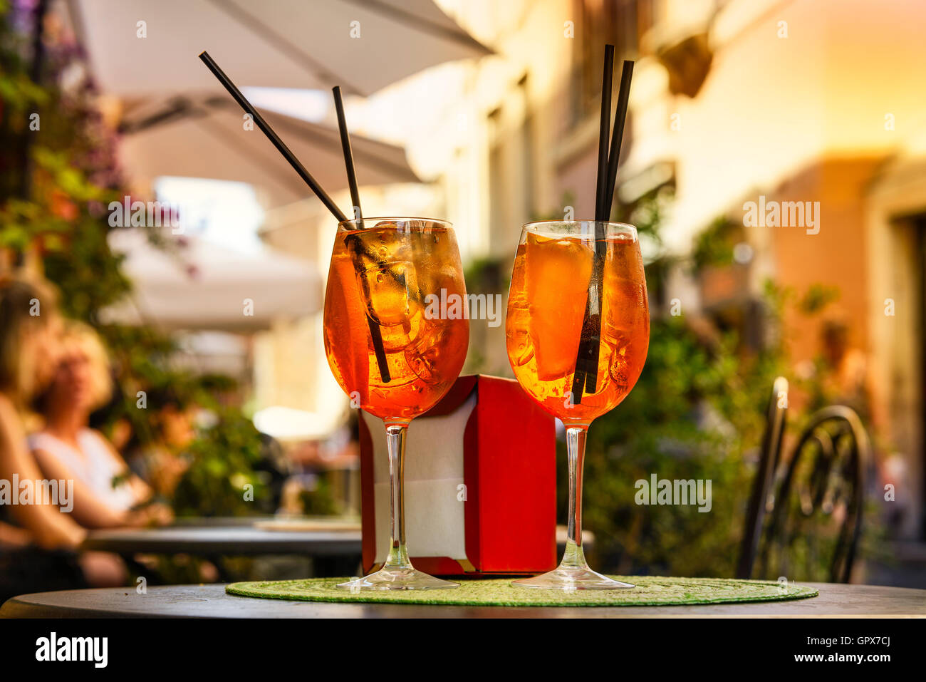 Aperol Spritz Cocktail. Alcoholic beverage based on table with ice cubes and oranges. Stock Photo