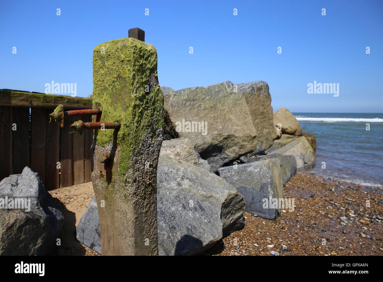 GROYNES - Sea defense rocks beach and sea and groin Norfolk  UK Stock Photo