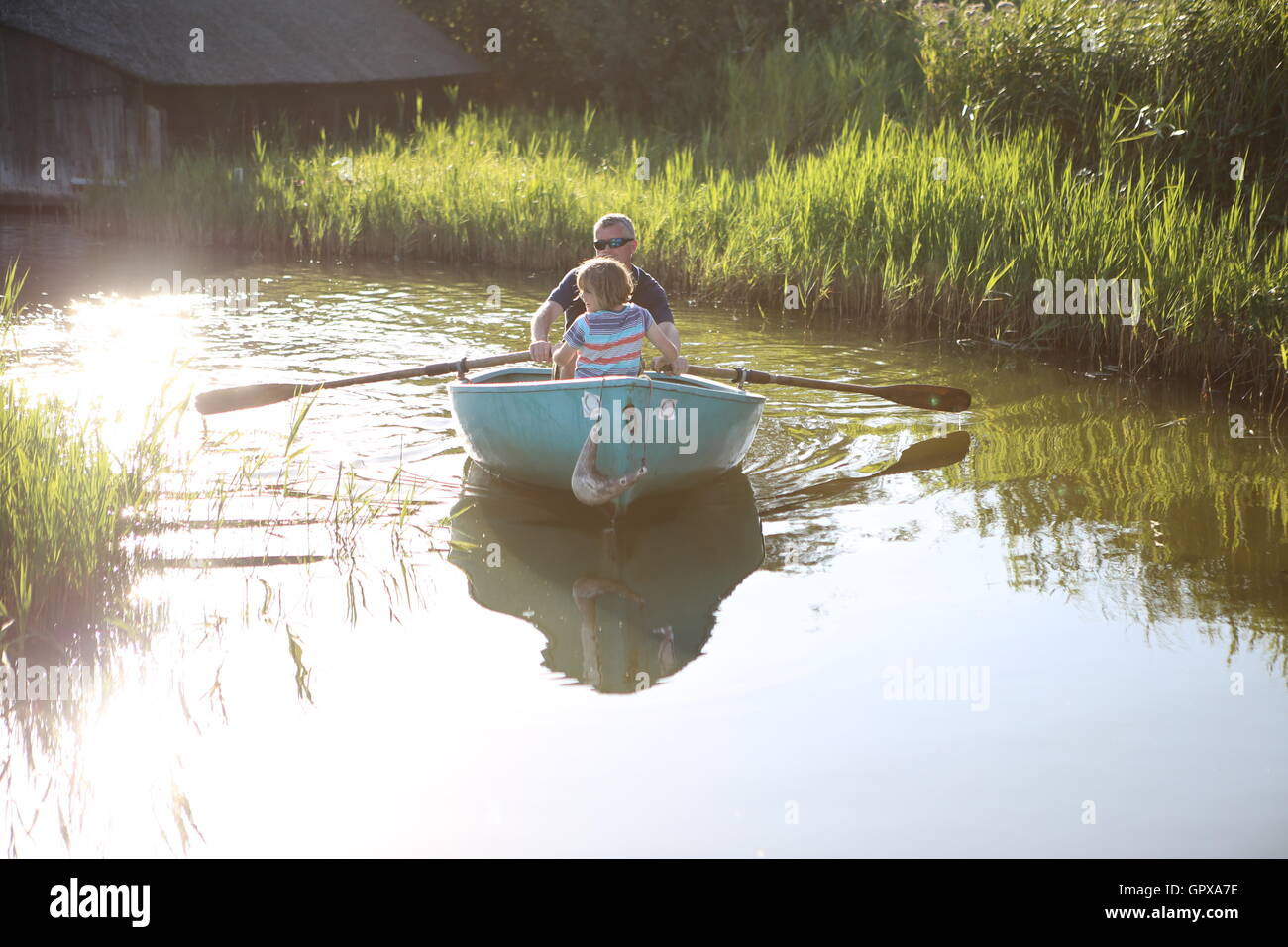 Man and child in rowing boat Norfolk broads UK Stock Photo Alamy