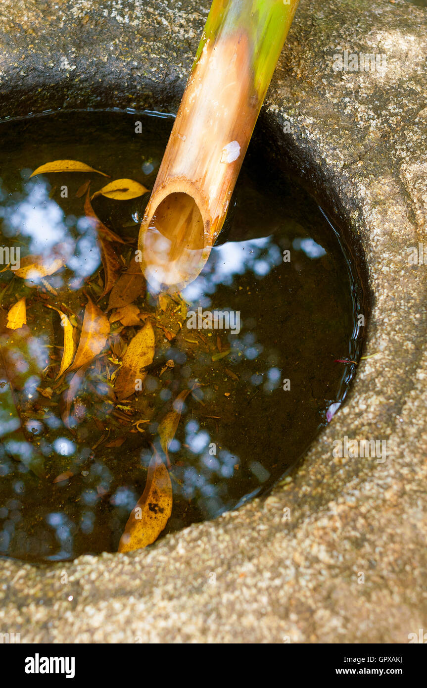 traditional Japanese water basin Tsukubai fragment with bamboo pipe