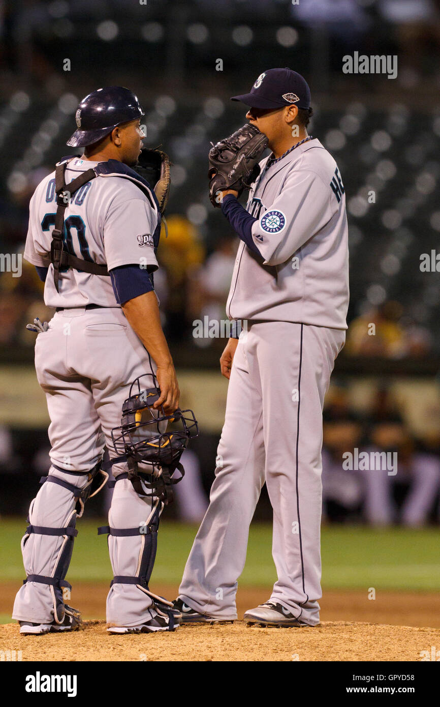 July 5, 2011; Oakland, CA, USA;  Seattle Mariners starting pitcher Felix Hernandez (right) talks to catcher Miguel Olivo (left) at the pitchers mound during the eighth inning against the Oakland Athletics at O.co Coliseum.  Seattle defeated Oakland 4-2 in Stock Photo
