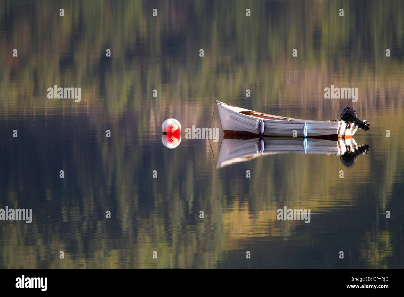 Reflection of moored boat on Loch Duich. Stock Photo