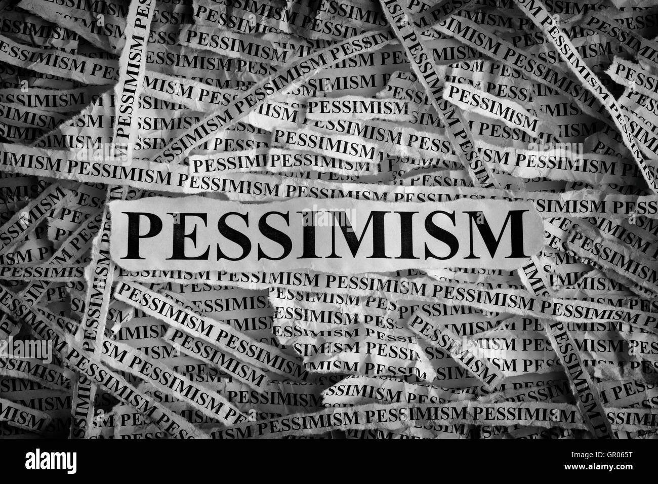 Pessimism. Torn pieces of paper with the word Pessimism. Concept Image. Black and White. Closeup. Stock Photo